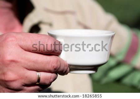 mans hand with cup of coffee
