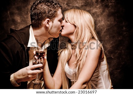 couple in love, kissing and holding glasses with wine