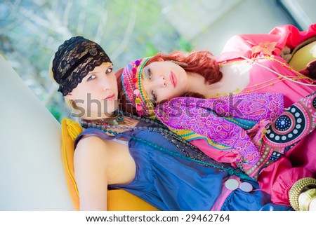 couple of women in oriental clothes sitting in garden
