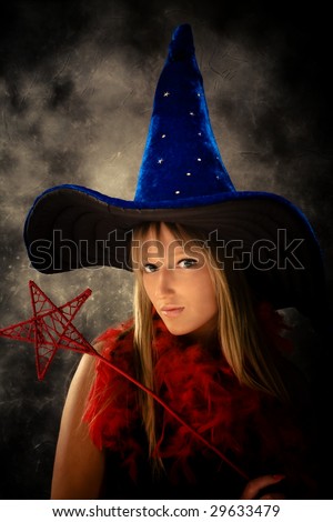 blond teenage girl with wizard hat and wand, studio shot