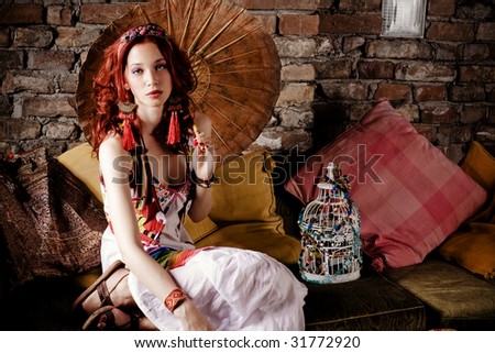 stock photo : beautiful red hair woman with japanese parasol sitting on sofa