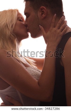 young couple in love, kissing, studio shot, back light