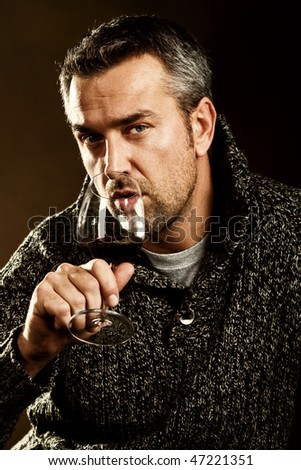 handsome adult man drinking red wine, studio shot