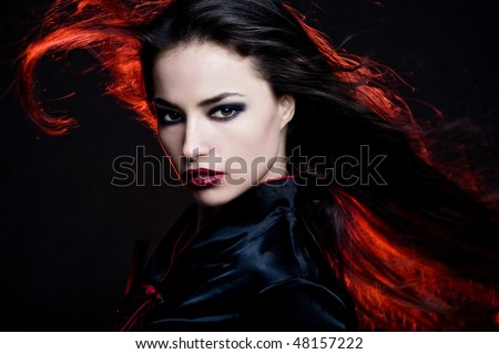 beautiful dark hair woman with hair in motion and red back light