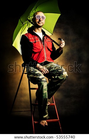 man with umbrella sit on ladder  waiting rain, studio shot
