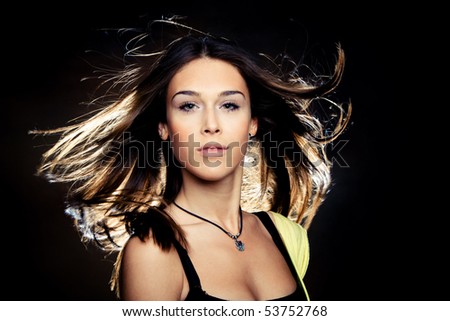 green eye young woman with long hair in motion, back light, studio shot