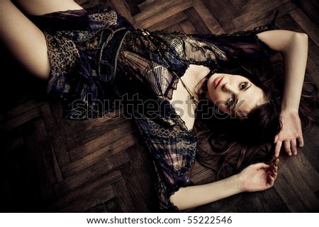young sensual woman in elegant dress lieing on the floor