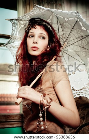 young romantic look woman portrait with parasol, indoor shot