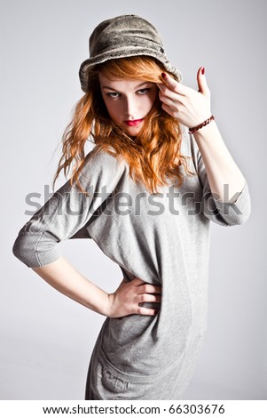 young red hair woman with hat in casual street clothes, studio shot