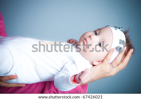 mother hold her baby girl in arms, studio shot
