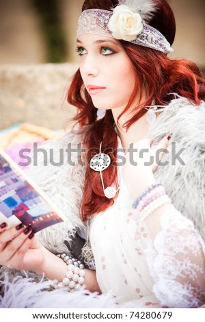 red hair woman in fashionable clothes  read book outdoor shot