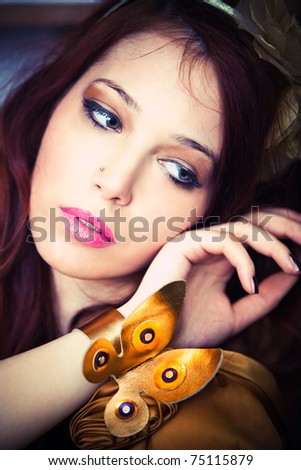 woman portrait with golden bracelet butterfly indoor shot