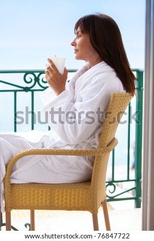 woman drink morning coffee at balcony in background sea and blue sky