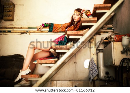 young woman in colorfull summer clothes sit on stairs indoor shot
