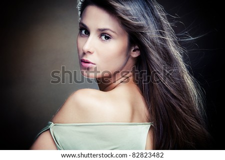 beautiful long hair brunette woman portrait, dark background,  studio shot