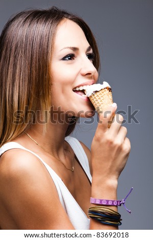 young happy woman eat icecream, studio shot