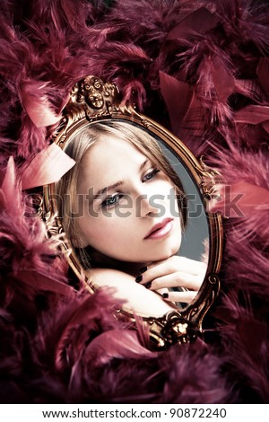 beautiful young woman reflection in mirror surrounded by plumage