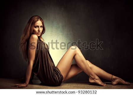 young woman in elegant short dress sit  barefoot, full body shot, studio shot