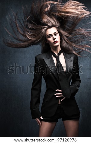 beautiful fashion woman model in tuxedo jacket, tie with long flying hair