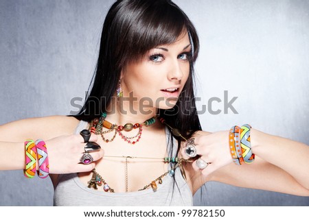cute  girl with lot of necklaces, bracelets and rings studio shot