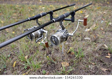 Carp fishing rods and reels on the stand at the shore of the lake