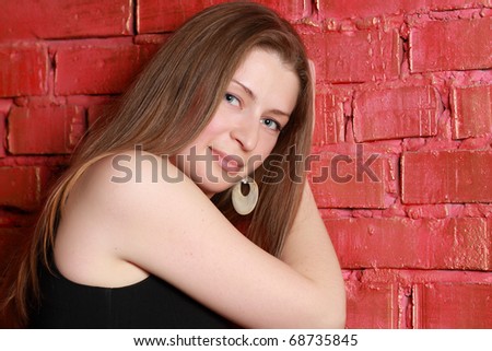 Portrait of the young charming girl indoors against a red wall and curtains