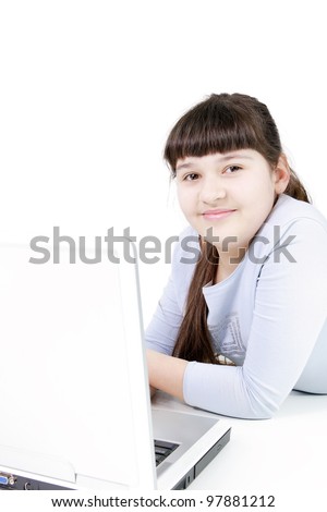 The girl the teenager with a smile at the computer on the isolated white background