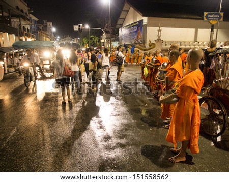 CHIANG MAI THAILAND-AUGUST 20 : Night give food offerings.People attending the Night offering alms to adopted the traditions come together. Annual basis at .on August 20,2013 in Chiangmai,Thailand