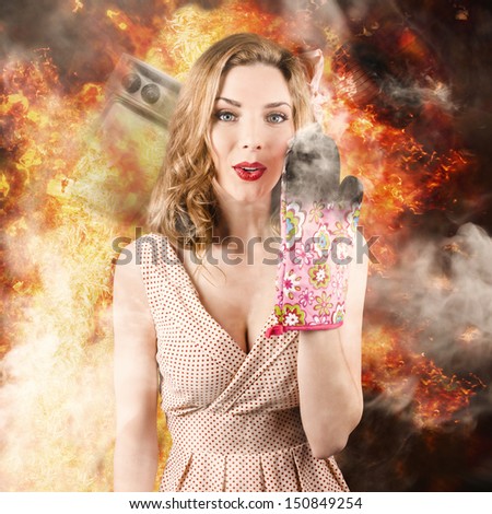 Funny image of a surprised woman cook setting the kitchen alight in a burst of fire and smoke.  Bad cooking