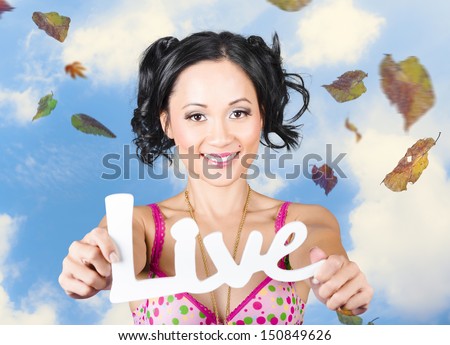 Outdoor portrait of a young girl holding out hands in joy and happiness to display the words live. Motivational words from a life coach