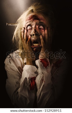 Dark Horror Portrait Of A Dying Bloody Zombie Griping Face With Hands In Fear And Terror While Looking Up To The Light. A Passing Scream Between Heaven And Hell
