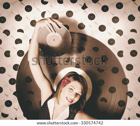 Vintage pin-up girl holding old LP when spinning vinyl discs at a vintage radio station. Rock around the clock