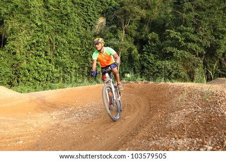 Man are riding mountain bikes uphill in a desert landscape.