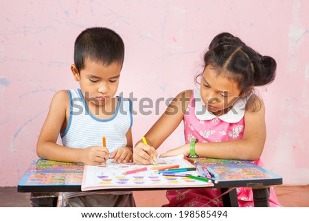 girl with her brother doing school home-work.