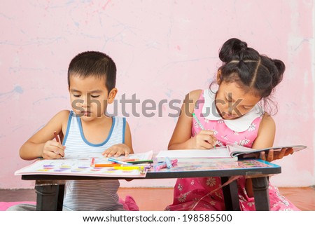 girl with her brother doing school home-work.