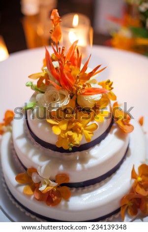 Wedding cake ; Set the focus on the flowers on top of the wedding cake.