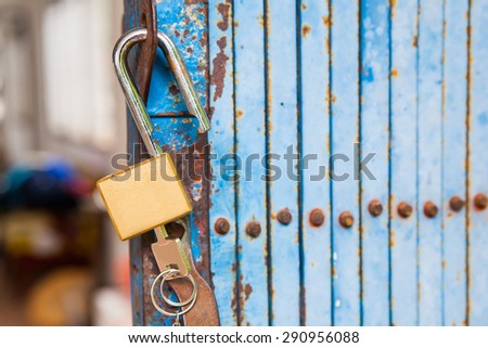 Old open padlock and key with old steel door