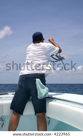 A fisherman throwing the boat anchor minutes before anchoring the  boat