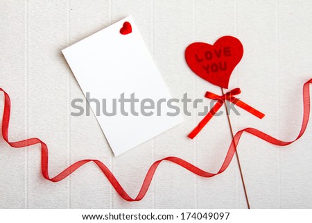 Fabric Love You heart with an empty postcard and a red ribbon on