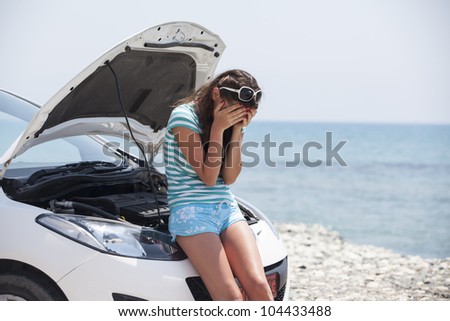 the girl cries over the broken car. Nice girl with the broken auto