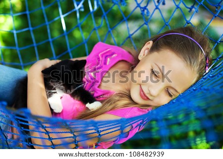 the girl sleep in a hammock with a cat in the open air
