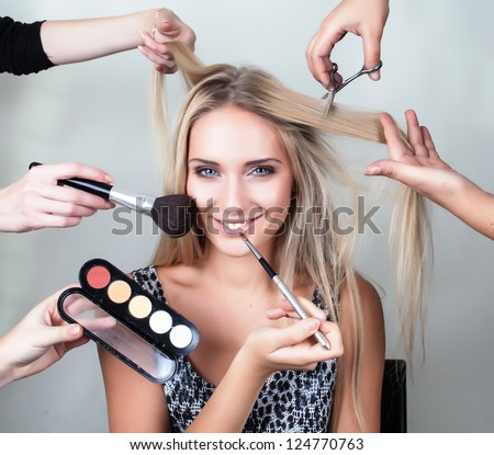 Many Hands Applying Make Up On A Woman Head