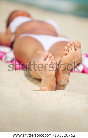 woman in bikini lying and sunning on the beach