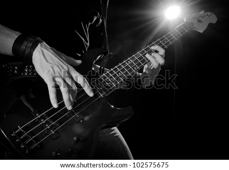rock concert: bass guitarist playing on stage