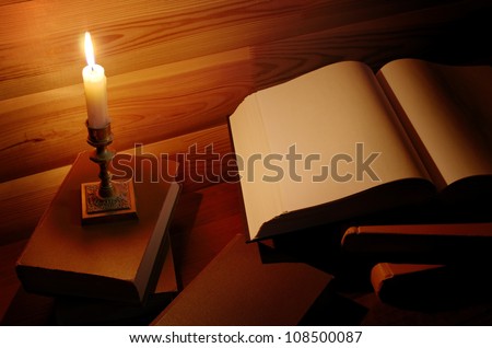retro educational and reading still life: candle near an open book