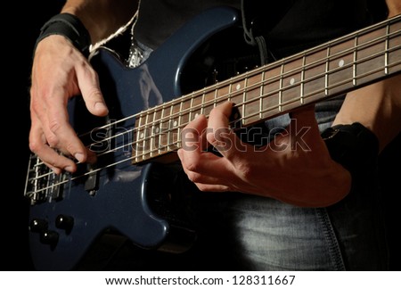 closeup shot of bass guitar in hands of musician