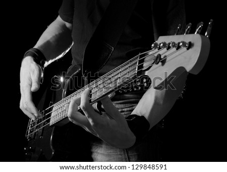 electrical bass guitar in hands, black and white
