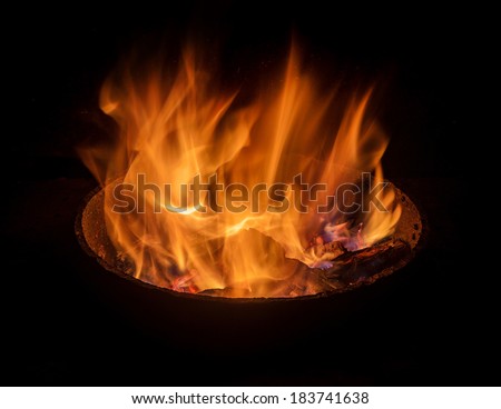 fire in round fireplace, dark background