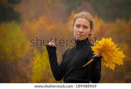 half-length portrait of girl in with marple leaves in park