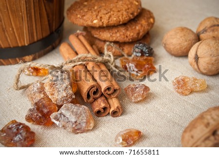 still life of brown sugar, cinnamon sticks and oat cookies on linen background